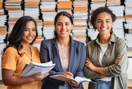 3 people smiling near papers