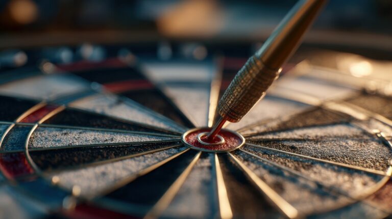 A close up of a dart board with a dart in in the exact center.
